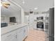Modern kitchen with stainless steel appliances, white cabinetry, mosaic backsplash and wood-look floors at 1005 Richard Dr, The Villages, FL 32159