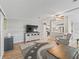 Bright living room with wood floors, a ceiling fan, and a large cutout looking into the kitchen at 1005 Richard Dr, The Villages, FL 32159