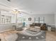 Comfortable living room boasts light wood floors, a ceiling fan, neutral paint and a large window with blinds at 1005 Richard Dr, The Villages, FL 32159