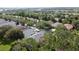 Aerial view of a neighborhood featuring lush greenery and mature trees surrounding well-maintained homes at 101 Flame Vine Way, Groveland, FL 34736