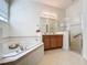 Bathroom with a large soaking tub, tiled shower, and double vanity at 101 Flame Vine Way, Groveland, FL 34736