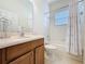 Bathroom featuring wood cabinets, white tiled shower and toilet at 101 Flame Vine Way, Groveland, FL 34736