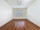 A bright bedroom featuring hard wood floors, and a large window at 101 Flame Vine Way, Groveland, FL 34736