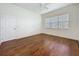 A bright bedroom featuring hard wood floors, a large window and a white ceiling fan at 101 Flame Vine Way, Groveland, FL 34736
