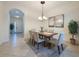 Inviting dining room with modern chandelier, neutral tones, and tiled flooring at 101 Flame Vine Way, Groveland, FL 34736