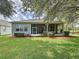 The home features a screened in patio overlooking a lush green backyard at 101 Flame Vine Way, Groveland, FL 34736