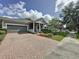 Charming single-story home with a two-car garage, landscaped yard, and brick paved driveway at 101 Flame Vine Way, Groveland, FL 34736