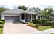 Well-maintained single-story home with a charming brick driveway, two car garage and lush landscaping at 101 Flame Vine Way, Groveland, FL 34736