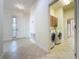 Bright hallway and laundry area with tiled floors, a washing machine and a dryer at 101 Flame Vine Way, Groveland, FL 34736