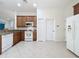 Large, bright kitchen featuring wood cabinets, stainless steel appliances and neutral tile floor at 101 Flame Vine Way, Groveland, FL 34736