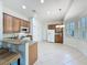 Well-lit kitchen featuring a breakfast bar, stainless steel appliances and light, neutral-toned tile floors at 101 Flame Vine Way, Groveland, FL 34736