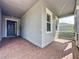 Covered front porch featuring brick flooring and a welcoming entrance at 101 Flame Vine Way, Groveland, FL 34736