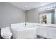 Well-lit bathroom with soaking tub, white vanity, and sleek fixtures for a spa-like experience at 1132 Hill Mount Dr, Minneola, FL 34715