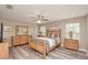 Serene bedroom featuring wood laminate flooring, a ceiling fan, and ample natural light through the windows at 1132 Hill Mount Dr, Minneola, FL 34715