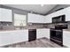 Modern kitchen with sleek white cabinets, stainless steel appliances, and durable laminate flooring at 1132 Hill Mount Dr, Minneola, FL 34715