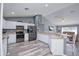 Open kitchen with stainless appliances, breakfast bar, laminate flooring, and seamless flow into living area at 1132 Hill Mount Dr, Minneola, FL 34715
