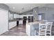 Bright kitchen featuring white cabinetry, a breakfast bar, laminate flooring, and a modern aesthetic at 1132 Hill Mount Dr, Minneola, FL 34715