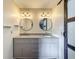 Stylish bathroom vanity with double sinks, granite countertop, round mirrors, and modern lighting at 1156 Capella Dr, Tavares, FL 32778