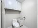 Bright bathroom with a glass enclosed shower, toilet, and built in shelving with upper cabinets at 1156 Capella Dr, Tavares, FL 32778