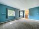 Cozy bedroom with plush carpeting, bright windows, and fresh teal-painted walls at 1156 Capella Dr, Tavares, FL 32778