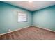 Inviting bedroom with soft carpeting, light teal walls, and a window with blinds at 1156 Capella Dr, Tavares, FL 32778