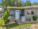 Welcoming front entrance with a white door, decorative lattice, and colorful landscaping, creating a charming curb appeal at 1156 Capella Dr, Tavares, FL 32778