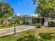 Single-story home with a well-manicured lawn, mature landscaping, and a convenient carport in a serene setting at 1156 Capella Dr, Tavares, FL 32778