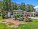 Inviting single-story home featuring a lush front yard with mature trees and vibrant landscaping in a tranquil neighborhood at 1156 Capella Dr, Tavares, FL 32778