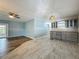 Open-concept living room with updated gray kitchen cabinets and stainless steel appliances at 1156 Capella Dr, Tavares, FL 32778