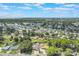 Aerial view highlights waterfront homes surrounded by trees within a vibrant residential neighborhood at 11750 Watts Ct, Tavares, FL 32778