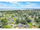 Aerial view shows waterfront property surrounded by lush greenery in a residential neighborhood by a lake at 11750 Watts Ct, Tavares, FL 32778