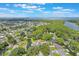 Overhead image displays waterfront homes nestled within a tree-lined community near open water and a bridge at 11750 Watts Ct, Tavares, FL 32778