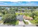 Aerial view of a quaint neighborhood home with mature trees and water access at 11750 Watts Ct, Tavares, FL 32778