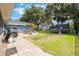 Expansive backyard with patio, lush lawn, mature trees, and a trampoline at 11750 Watts Ct, Tavares, FL 32778