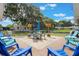 Outdoor seating area on backyard patio, surrounded by lush landscaping at 11750 Watts Ct, Tavares, FL 32778