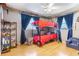 Bedroom featuring a bunk bed with a wooden floor and open shelf for toy storage at 11750 Watts Ct, Tavares, FL 32778