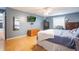 Spacious bedroom with laminate wood floors, ceiling fan, and a wall-mounted television at 11750 Watts Ct, Tavares, FL 32778