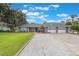 A well-maintained home exterior showcases a three-car garage, landscaped front yard, and charming curb appeal at 11750 Watts Ct, Tavares, FL 32778