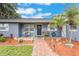 Charming front entrance with a beautiful wreath, cozy benches, and landscaped garden beds creates a warm and inviting welcome at 11750 Watts Ct, Tavares, FL 32778