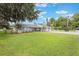 Spacious front yard features lush green grass, mature trees, and a well-maintained exterior, enhancing curb appeal at 11750 Watts Ct, Tavares, FL 32778