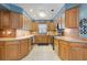 Well-lit kitchen features wood cabinets, stainless appliances, and plenty of countertop space at 11750 Watts Ct, Tavares, FL 32778
