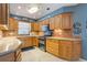 Kitchen with stainless double oven and cooktop, wood cabinetry and neutral countertops at 11750 Watts Ct, Tavares, FL 32778