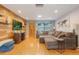 Inviting living room with wood-look floors, a large sectional sofa, a wood-paneled accent wall, and recessed lighting at 11750 Watts Ct, Tavares, FL 32778