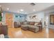 Spacious living room features an oversized sectional sofa, wood-look floors, and stylish decor, perfect for entertaining at 11750 Watts Ct, Tavares, FL 32778