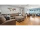 Bright living room features a large sectional sofa, wood-look floors, and a view into a separate sitting area at 11750 Watts Ct, Tavares, FL 32778