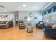 Comfortable living room featuring plush seating, warm wood floors, and natural light from large window at 11750 Watts Ct, Tavares, FL 32778