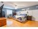 Spacious main bedroom with wood floors, ceiling fan, and neutral color palette at 11750 Watts Ct, Tavares, FL 32778