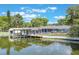 The waterfront includes a covered dock, screened porch, and backyard with lush landscaping at 11750 Watts Ct, Tavares, FL 32778