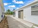 Enclosed back porch and patio area with white siding and a landscaped yard at 1199 Mathews Ln, The Villages, FL 32162