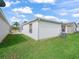 Backyard featuring well-maintained lawn, white siding, and an air conditioning unit at 1199 Mathews Ln, The Villages, FL 32162